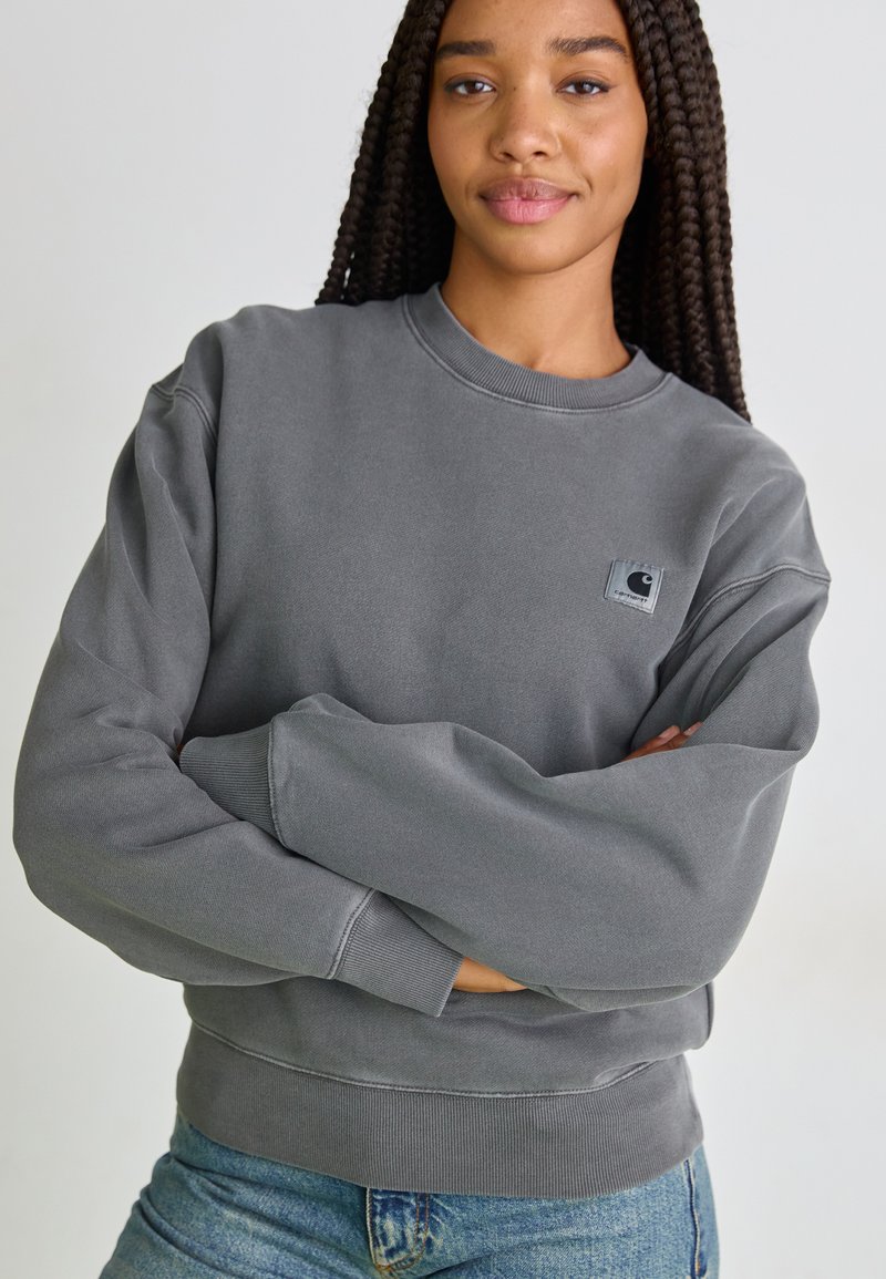Grijze sweatshirt met ribgebreide manchetten en onderrand, met een klein logopatch aan de linkerkant. Gemaakt van een zachte, gestructureerde stof.