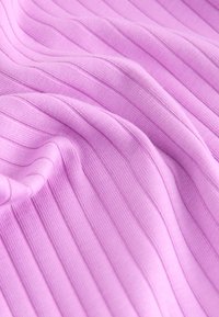 Lyse lilla ribbet stof med en blød tekstur, der har lodrette striber, som skaber et diskret mønster på materialet.