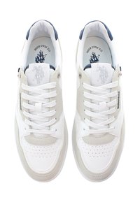 Bílé sportovní boty s béžovými semišovými detaily, kulatá špička, perforovaný přední díl, bílé tkaničky a logo na jazyku. Gumová podrážka a polstrovaný límec.