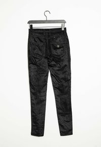 Černé sametové kalhoty s hladkým povrchem, slim fit a dvěma zadními kapsami. Obsahují malé logo značky poblíž pasu.