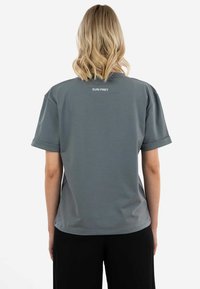 Gray short-sleeve t-shirt with rolled cuffs, featuring a smooth texture and logo "SURI FREY" printed on the upper back.