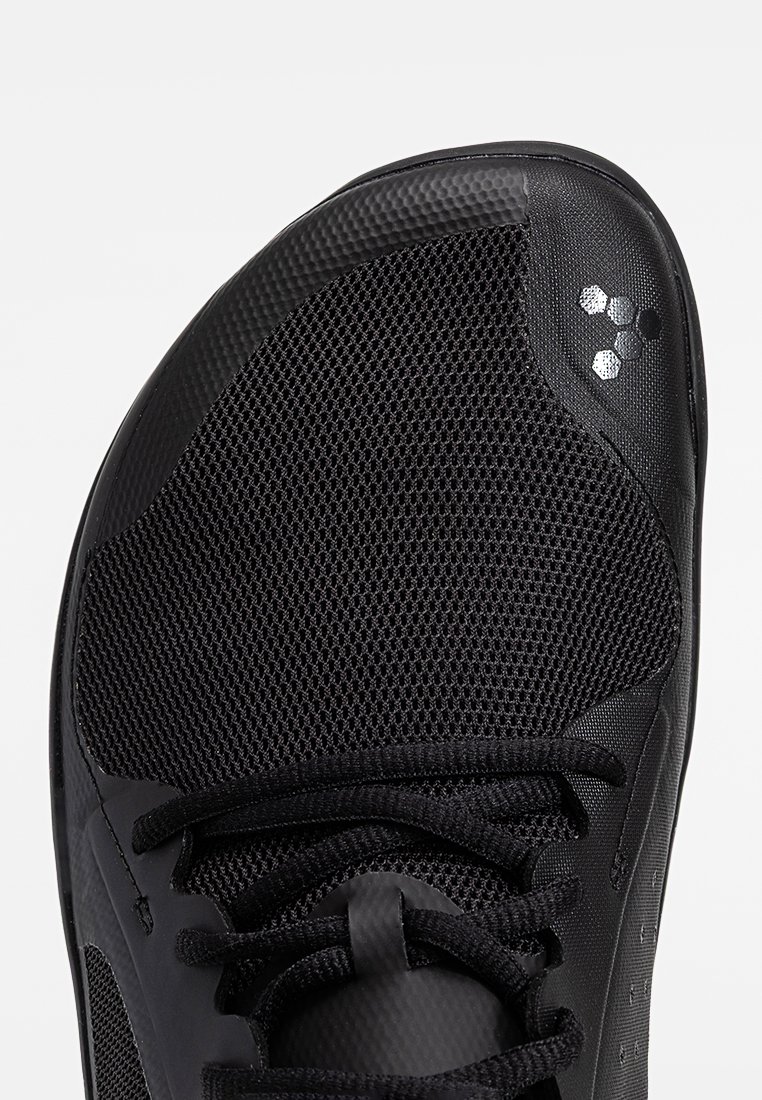 Zwarte sportieve schoen met een bovenwerk van mesh, gestructureerde synthetische overlays en ronde veters. Bevat reflecterende accenten en een ronde neus.