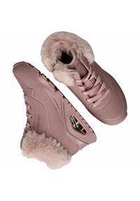 Różowe trampki z futerkiem, okrągłym noskiem, perforowaną cholewką i sznurowaniem. Posiadają amortyzowaną podeszwę oraz widoczną jednostkę powietrzną.