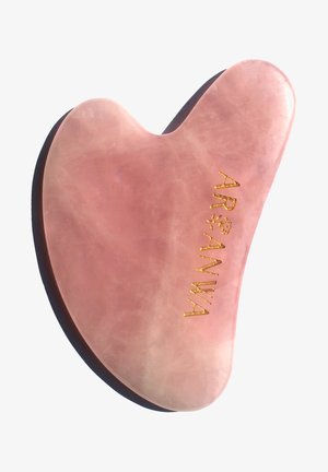 Rose quartz gua sha tool with a smooth, curved design and a gold logo. Features a pink hue and translucent texture.