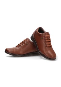 Zapatos de cuero marrón con puntera redondeada, cordones en la parte delantera y suelas de goma oscura contrastantes; textura suave con detalles de costura sutiles.