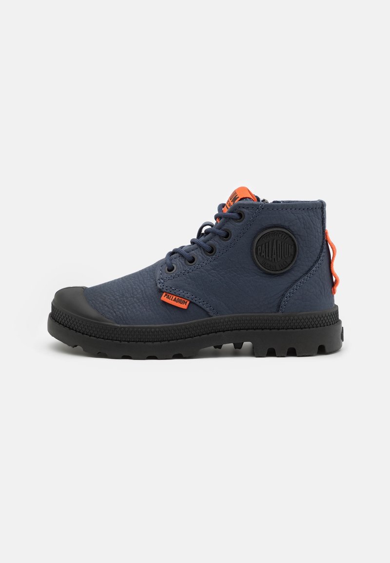 Bottines bleu marine avec matériau texturé, bout en caoutchouc et semelle noire. Comprend une languette de tirage orange et un patch de marque sur le côté.