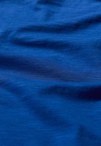 Mélykék szövet sima textúrával, árnyalatainak finom eltéréseivel és finom szövési mintával. Puha és enyhén fényes felület.