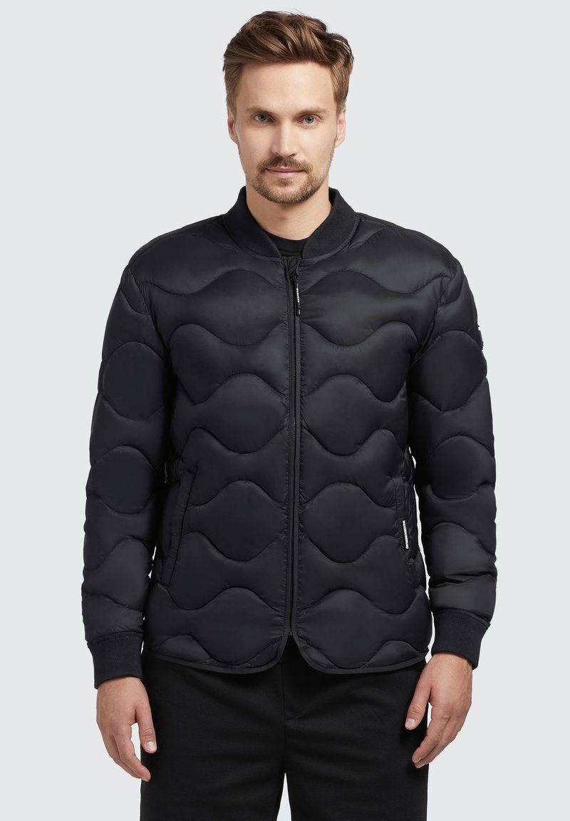 Black padded jacket featuring a wave pattern, zip closure, ribbed cuffs, and a round collar, made of smooth, water-resistant fabric.