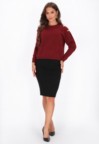 Bordowy dzianinowy sweter z odkrytymi ramionami, w połączeniu z dopasowaną czarną spódnicą ołówkową i czarnymi szpilkami. Gładka tekstura, casualowy design.