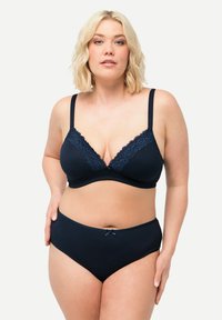 Marinblå bh med spetsdetaljer och V-ringning, parat med enfärgade marinblå högmidjade trosor med en liten rosettaccent. Slät, stretchig tyg.