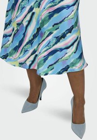 Mekko, jossa on sinisen, vihreän ja vaaleanpunaisen kiehtova kuvio, yhdistettynä vaaleansinisiin korkokenkiin. Silkkinen kangas ja tyylikkäät muotoilu yksityiskohdat.