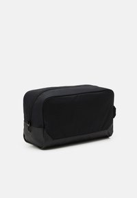 Black rectangular toiletry bag made of fabric with a textured finish, featuring a smooth black base and a top zipper closure.