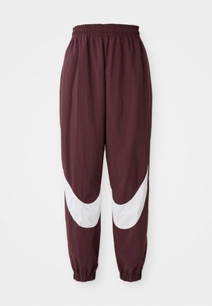 Pantaloni da allenamento color bordeaux con un design a strisce curve bianche, vita elastica e polsini affusolati. Realizzati in materiale leggero e traspirante.