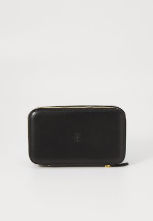 Carteira de couro preto com textura suave, forma retangular e fecho dourado. Apresenta um logotipo em relevo na parte da frente.