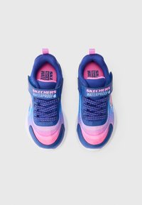 Scarpe sneaker impermeabili per bambini Skechers, blu e rosa, con cinturini in Velcro e lacci decorati, viste dall'alto su una superficie bianca.