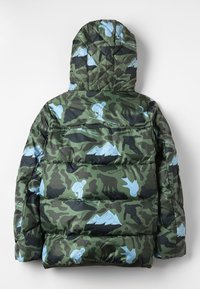 Parka acolchada con un patrón de camuflaje verde y gráficos de esquí y fauna en azul claro, que presenta una textura acolchada y capucha.