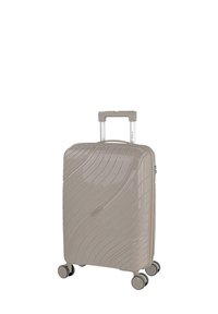 Maleta rígida en beige brillante, con textura ondulada, asa retráctil, cuatro ruedas giratorias y un compartimento con cremallera.