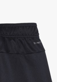 Černé sportovní šortky se staženým pasem. Na boku mají bílou značku 'CLIMALITE'. Hladká, lehká textura látky.