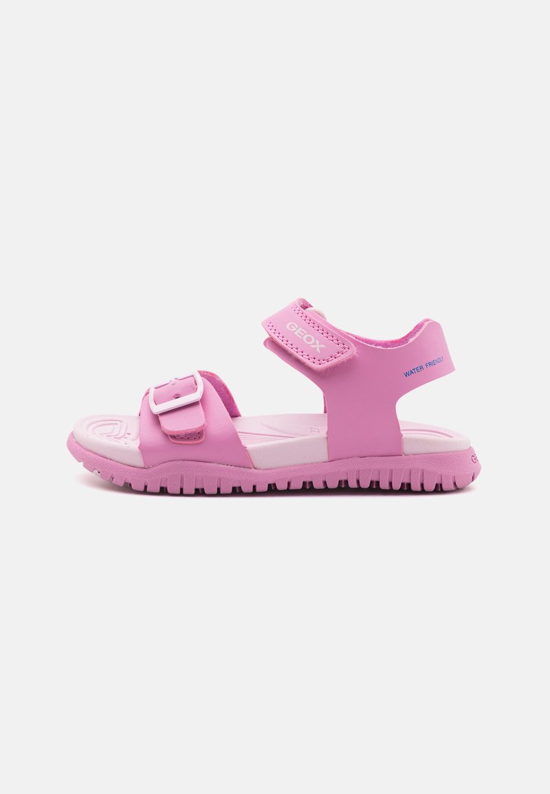 Sandalias rosas aptas para el agua con correas ajustables de Velcro, suela texturizada y acento de hebilla extraíble. Fabricadas con material ligero.