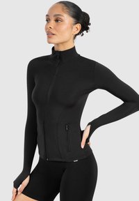 Black athletic jacket with a high collar, long sleeves, and zippered pocket. Made of smooth material, featuring fitted design.