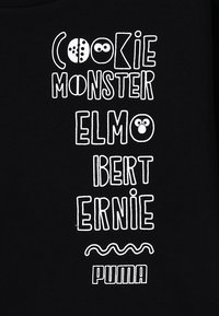 Felpa nera con cappuccio caratterizzata da testo bianco con i nomi dei personaggi: "COOKIE MONSTER," "ELMO," "BERT," "ERNIE," e "PUMA," con font e accenti giocosi.