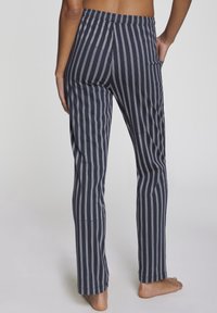 Striped navy lounge pants with white vertical lines, elastic waistband, and straight legs. Fabric appears soft and lightweight.