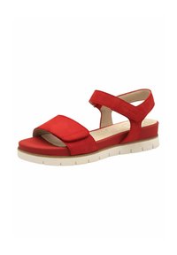 Sandal rossa regolabile con una larga fascia per le dita e una cinghia per la caviglia, realizzata in materiale morbido, con una suola texturizzata e una base piatta bianca.