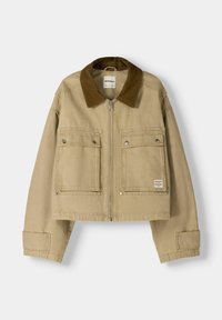 Beżowa kurtka typu cropped uszyta z mocnego materiału, z brązowym kołnierzem z sztruksu, dwoma przednimi kieszeniami z zatrzaskami oraz centralnym zamkiem błyskawicznym.