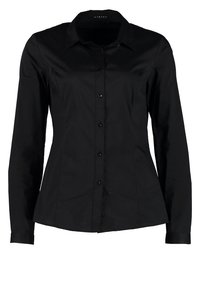 Chemise noire à manches longues en tissu lisse, dotée d'un col pointu, d'une fermeture boutonnée à l'avant et d'une silhouette ajustée avec des détails subtils à l'ourlet.