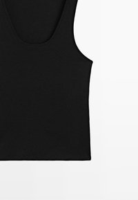 Débardeur en tissu côtelé noir avec un col arrondi et de larges bretelles, présenté sur un fond blanc.