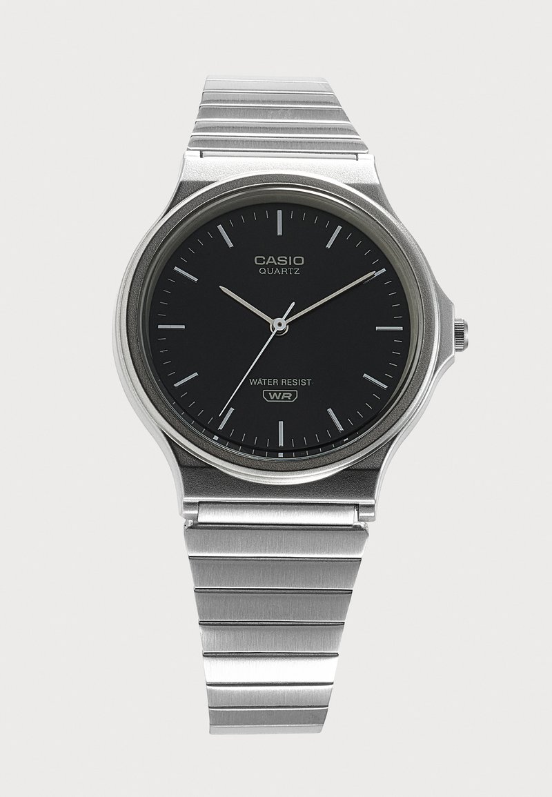 Ασημένιο ρολόι Casio quartz με μαύρο καντράν, ασημένιους δείκτες ώρας, τρεις δείκτες και μπρασελέ από μέταλλο, δείχνει 10:10:36.
