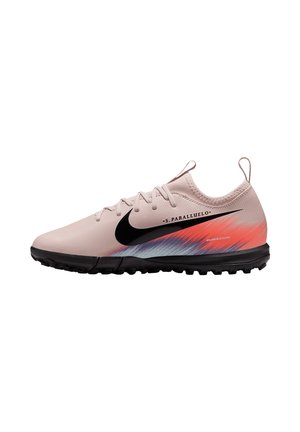 Scarpe da calcio Nike di colore rosa chiaro con logo nero, caratterizzate da un design a gradiente con accenti rossi e blu, superficie testurizzata e suola nera.
