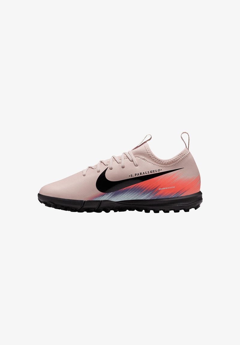 Scarpe da calcio Nike di colore rosa chiaro con logo nero, caratterizzate da un design a gradiente con accenti rossi e blu, superficie testurizzata e suola nera.