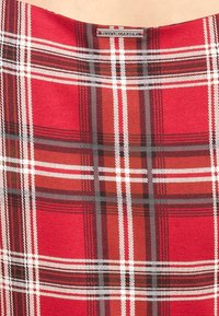 Tissu à carreaux rouges avec des lignes blanches et noires, présentant une texture lisse et une étiquette portant la mention "VIVE MARIA".