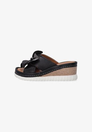 Black leather wedge sandals with crossover strap design, featuring a textured outsole and a light wood accent on the wedge.
