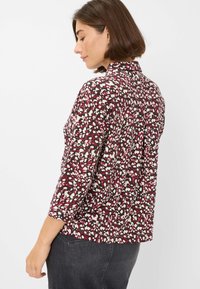 Langsleeve shirt in een bordeauxrode, witte en zwarte abstracte print; zachte stof met een ontspannen pasvorm; heeft een kleine kraag en een ronde zoom.