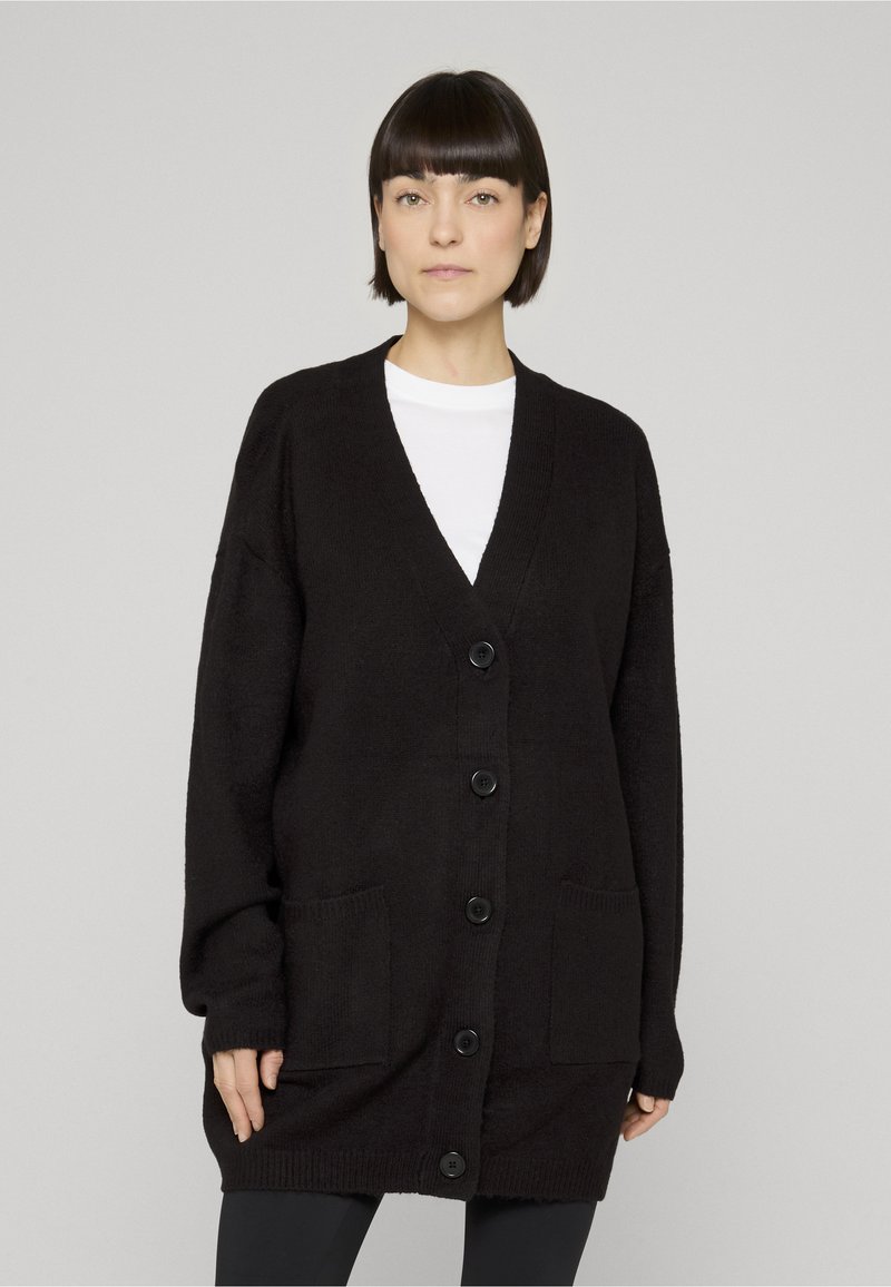 Črni pleteni kardigan z V-izrezom, dolgimi rokavi, gumbi spredaj in dvema stranskima žepoma. Iz mehkega, teksturiranega platna.