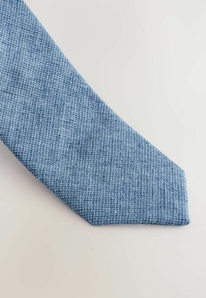 Tekstuuriga sinine lips diagonaalse kudumisega. Kanga välimus on pehme ja matt, sellel on klassikaline kitsas kuju terava otsaga.