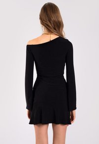 Schwarzes schulterfreies Kleid mit langen Ärmeln, figurbetontem Oberteil und ausgestellt Rock. Glatte Textur mit minimaler Verzierung und ohne sichtbare Muster.