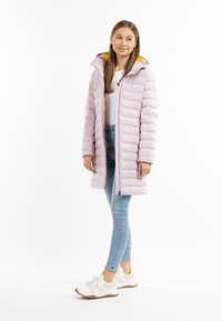 Lyserød dunjakke med hætte, med gul foring. Sammen med lyseblå stramme jeans og hvide sneakers med gule detaljer.