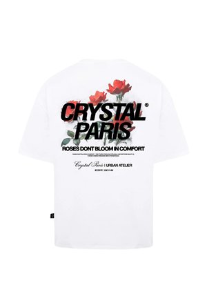 T-shirt bianco in cotone con grafica di rose rosse e bold testo nero che recita "CRYSTAL PARIS" e "LE ROSE NON FIORISCONO NEL COMFORT."