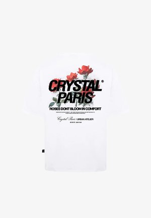 Witte katoenen t-shirt met een grafisch ontwerp van rode rozen en vetgedrukte zwarte tekst met de woorden "CRYSTAL PARIS" en "ROZEN BLOEIEN NIET IN COMFORT."