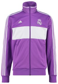 Fialová sportovní bunda s bílým vodorovným pruhem, s vysokým límcem, na zip, s logem Adidas a znakem Real Madrid, vyrobená z hladkého materiálu.