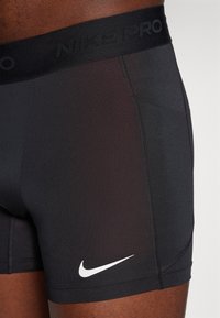 Svarta Nike Pro boxerkalsonger i ett stretchigt material. Funktioner ett vitt logo på sidan och en texturerad midja med "Nike Pro"-text.