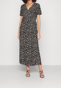 Robe portefeuille noire à manches courtes, présentant un motif floral blanc et rose sur un tissu texturé, se déclinant jusqu'à la longueur mi-mollet.