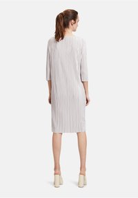 Hellgraues, knielanges Kleid mit vertikalen Falten, Dreiviertelärmeln und rundem Halsausschnitt. Glatte Textur, schlichtes Design, keine sichtbaren Verschlüsse.