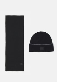 Set di sciarpa e berretto lavorati a maglia neri, con una texture a coste. Il berretto ha una fascia a righe grigie e un'etichetta con il logo. Materiale liscio, design classico.