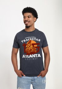 Mörkgrå bomulls-T-shirt med ett grafiskt tryck av en motorcykelåkare med texten: "International Trackstar Atlanta Raceway."