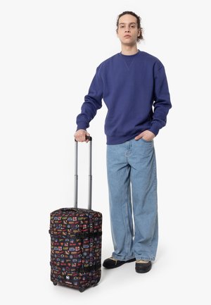 Rolling suitcase with a black fabric featuring colorful superhero logos, two smooth wheels, and a retractable silver handle.