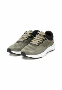 Zapatillas deportivas en gris y negro con una parte superior de malla transpirable, diseño de cordones, collar acolchado y una entresuela blanca. Presentan patrones texturizados notables.